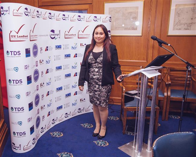 Fatima standing proud with all the company logos that have sponsored the event